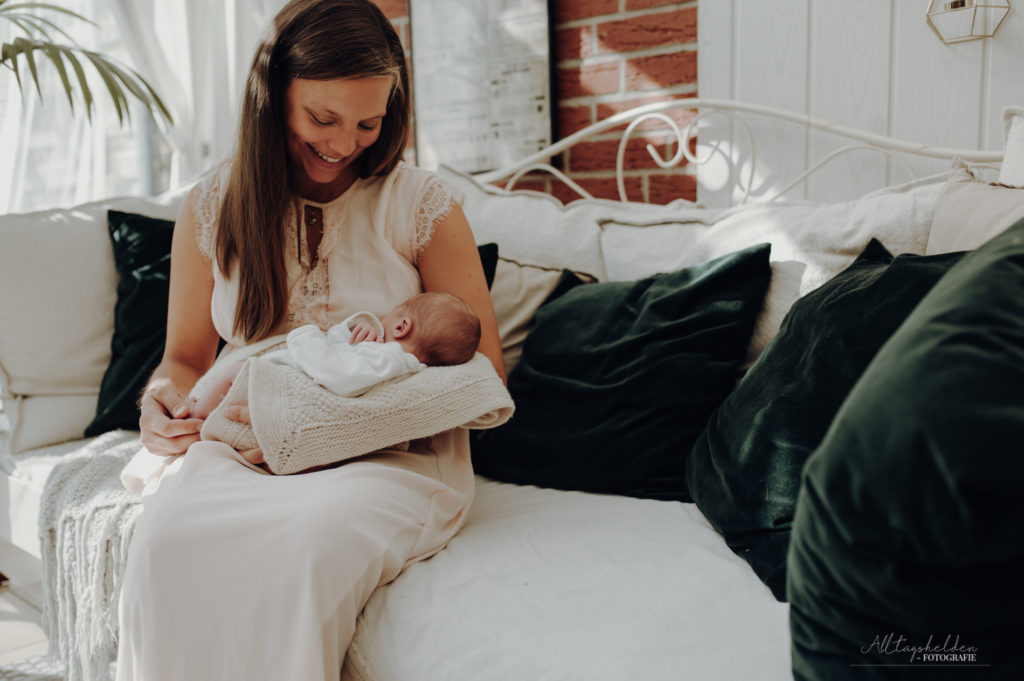 Mama hält das Neugeborene - Babyfotografin Eutin